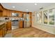 Bright kitchen boasts stainless appliances, wood cabinets, and natural light from window with shutters at 1801 E Lake Rd # 11A, Palm Harbor, FL 34685