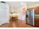 Light filled dining area with a wooden table and chairs and stainless steel refrigerator in the adjacent kitchen at 18155 Canal Pointe St, Tampa, FL 33647