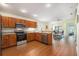 Bright kitchen with wooden cabinets, stainless steel appliances, granite countertops, and an adjacent living area at 18155 Canal Pointe St, Tampa, FL 33647