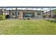 Screened-in backyard with lush green lawn and space for outdoor living at 20237 Bandera Pl, Venice, FL 34293