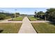 Bocce ball courts with green artificial turf near a lake, with a sidewalk, benches and landscaping at 20237 Bandera Pl, Venice, FL 34293