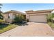 Attractive home with a paver driveway, manicured lawn, and an attached two-car garage at 20237 Bandera Pl, Venice, FL 34293