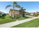 Landscaped front yard of this home showcasing lush green grass, mature trees, and easy sidewalk access at 20237 Bandera Pl, Venice, FL 34293