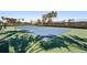 An outdoor tennis court featuring a green and blue surface, surrounding fence, and shade trees in the background at 20237 Bandera Pl, Venice, FL 34293