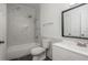 Bathroom featuring tub with marble tile surround, toilet, sink and a dark-colored floor at 2171 Portofino Place # 27-2725, Palm Harbor, FL 34682