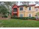 Two-story villa with a screened balcony, large windows, and well-maintained landscaping, offering a comfortable outdoor space at 2171 Portofino Place # 27-2725, Palm Harbor, FL 34682