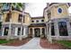 Stunning home featuring a stone facade, arched entry, and a meticulously landscaped front yard with mature palm trees at 2171 Portofino Place # 27-2725, Palm Harbor, FL 34682