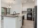 Well-lit kitchen featuring granite countertops, stainless steel appliances, and a breakfast bar with a sink at 2171 Portofino Place # 27-2725, Palm Harbor, FL 34682
