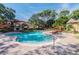 Inviting community pool with rock waterfall feature and poolside seating and mature trees at 2171 Portofino Place # 27-2725, Palm Harbor, FL 34682