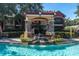 Inviting pool area featuring a waterfall, pergola, and lush landscaping, creating a serene outdoor retreat at 2171 Portofino Place # 27-2725, Palm Harbor, FL 34682