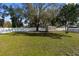 Expansive backyard featuring lush green grass, a storage shed, and a white fence at 21826 Pineywood Loop, Land O Lakes, FL 34639