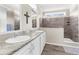 Bathroom with dual sinks, granite counters, tiled floors, and a glass-enclosed shower stall at 21826 Pineywood Loop, Land O Lakes, FL 34639