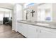 Bathroom with a granite countertop, dual sinks, framed mirrors, and white cabinets at 21826 Pineywood Loop, Land O Lakes, FL 34639