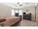 Bedroom showcasing a large bed, dark wood dresser, light-toned walls, and a ceiling fan at 21826 Pineywood Loop, Land O Lakes, FL 34639