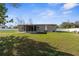 Single-story home featuring a screened porch and a well-maintained lawn under a partly cloudy blue sky at 21826 Pineywood Loop, Land O Lakes, FL 34639