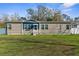 The home boasts well-maintained lawns, complemented by appealing blue accents at the entrance at 21826 Pineywood Loop, Land O Lakes, FL 34639