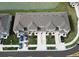 Aerial view of the townhouses with driveways, well-maintained lawns, and a nearby pond at 2411 Paravane Way, Wesley Chapel, FL 33543