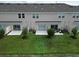 A back view of condos, each with a small patio and a grassy area at 2411 Paravane Way, Wesley Chapel, FL 33543