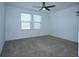 Carpeted bedroom with ceiling fan and two windows offering natural light at 2411 Paravane Way, Wesley Chapel, FL 33543