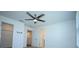 Upstairs bedroom with ceiling fan and a view into an adjacent closet and hallway at 2411 Paravane Way, Wesley Chapel, FL 33543