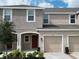 Charming townhouse featuring a private garage, manicured landscaping, and a welcoming front entrance at 2411 Paravane Way, Wesley Chapel, FL 33543