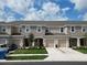 View of multiple townhouses featuring garages, neutral paint schemes, and well-maintained landscaping at 2411 Paravane Way, Wesley Chapel, FL 33543