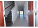 Bright foyer with staircase, neutral tile flooring, and an open view of the gathering room at 2411 Paravane Way, Wesley Chapel, FL 33543