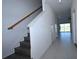 Bright foyer with staircase, neutral tile flooring, and an open view of the gathering room at 2411 Paravane Way, Wesley Chapel, FL 33543