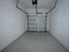 Clean, epoxy-floored garage offering ample space for vehicle storage and organization at 2411 Paravane Way, Wesley Chapel, FL 33543