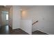 Upstairs hallway featuring wood floors and white trim leading to bedrooms and the laundry area at 2411 Paravane Way, Wesley Chapel, FL 33543