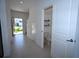 Bright hallway leading to a powder room and a glimpse of the outdoors at 2411 Paravane Way, Wesley Chapel, FL 33543