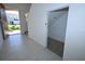 Hallway view toward front door and closet space, showcasing tile flooring at 2411 Paravane Way, Wesley Chapel, FL 33543