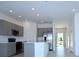 Modern kitchen with stainless steel appliances, gray cabinets, and a kitchen island at 2411 Paravane Way, Wesley Chapel, FL 33543
