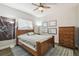 Cozy bedroom featuring a ceiling fan, a comfortable bed, and natural light from a window at 24355 Hideout Trl, Land O Lakes, FL 34639