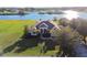 Stunning waterfront home featuring a well-manicured lawn and mature trees, offering serene lakeside living at 24355 Hideout Trl, Land O Lakes, FL 34639