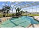 Enclosed pool features tropical landscaping, a rock waterfall and adjacent spa, with lake views at 24355 Hideout Trl, Land O Lakes, FL 34639