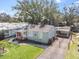 Front exterior view highlighting the house with a gated driveway and detached carport at 306 W Alva St, Tampa, FL 33603