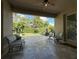 Relaxing covered patio with neutral toned pavers, comfortable seating, and lush backyard views at 3205 Majestic View Dr, Lutz, FL 33558