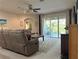 Cozy living room with ceiling fan, neutral decor, and sliding glass doors to the patio at 3205 Majestic View Dr, Lutz, FL 33558