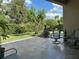 Covered patio with stone tile, outdoor furniture, and a lush backyard, perfect for relaxation at 3205 Majestic View Dr, Lutz, FL 33558