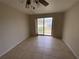 Bedroom with tile flooring, ceiling fan, and sliding glass door to the yard at 3223 Coats Rd, Zephyrhills, FL 33541