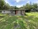Ranch-style home featuring stone veneer and a well-maintained lawn at 3223 Coats Rd, Zephyrhills, FL 33541