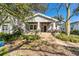 Charming home with a brick porch and columns is framed by a mature tree and professional landscaping at 3313 W Palmira Ave, Tampa, FL 33629