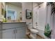 Bathroom featuring a single sink, granite countertop, soft gray cabinets, a large mirror, and a shower/bath at 34747 Telluride Ln, Zephyrhills, FL 33541
