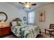 Bedroom with a full sized bed, ceiling fan, and palm tree themed comforter and artwork at 34747 Telluride Ln, Zephyrhills, FL 33541
