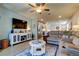 Bright living room with a large TV, comfortable seating, and open access to the kitchen at 34747 Telluride Ln, Zephyrhills, FL 33541