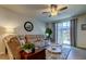 Cozy living room with plush seating, ceiling fan, and sliding door access to the lanai at 34747 Telluride Ln, Zephyrhills, FL 33541