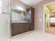 Bathroom boasts dual sinks, a walk-in shower, and tile flooring at 4920 Sevilla Shores Dr, Wimauma, FL 33598
