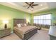 Comfortable bedroom features a tray ceiling and a ceiling fan at 4920 Sevilla Shores Dr, Wimauma, FL 33598