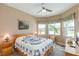 Cozy bedroom featuring a ceiling fan, a quilt, and natural light from multiple windows at 4920 Sevilla Shores Dr, Wimauma, FL 33598